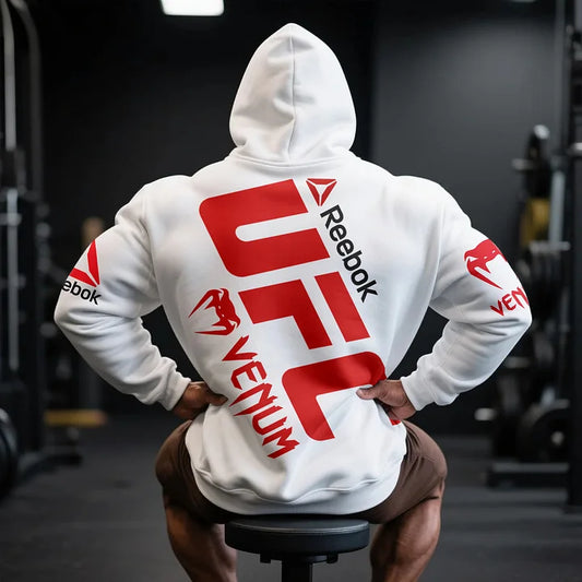 Biały hoodie VenuReebk z kapturem, czerwony design UFC na plecach, model noszony, styl sportowy.
