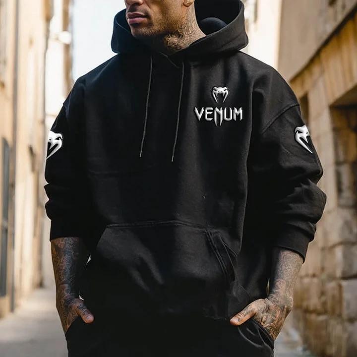 Czarny hoodie Venn z kapturem, białe logo Venum na piersi i symbole na rękawach, noszony przez mężczyznę, model casual.