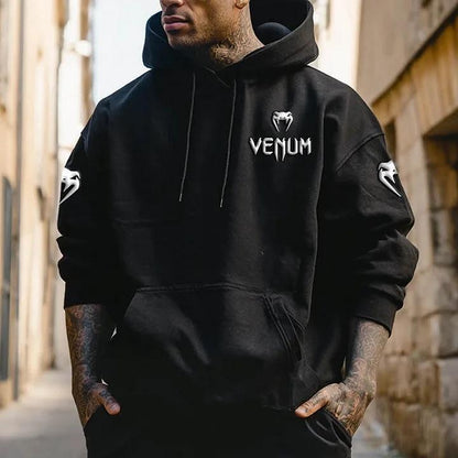 Czarny hoodie Venn z kapturem, białe logo Venum na piersi i symbole na rękawach, noszony przez mężczyznę, model casual.