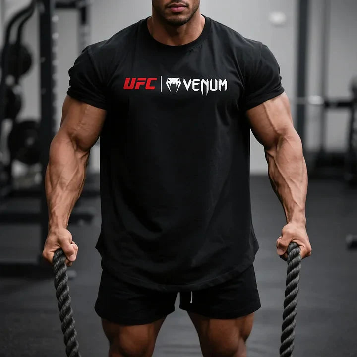 Mężczyzna muskularny w czarnej koszulce UFC Venum z bawełny organicznej, z krótkim rękawem, na siłowni.